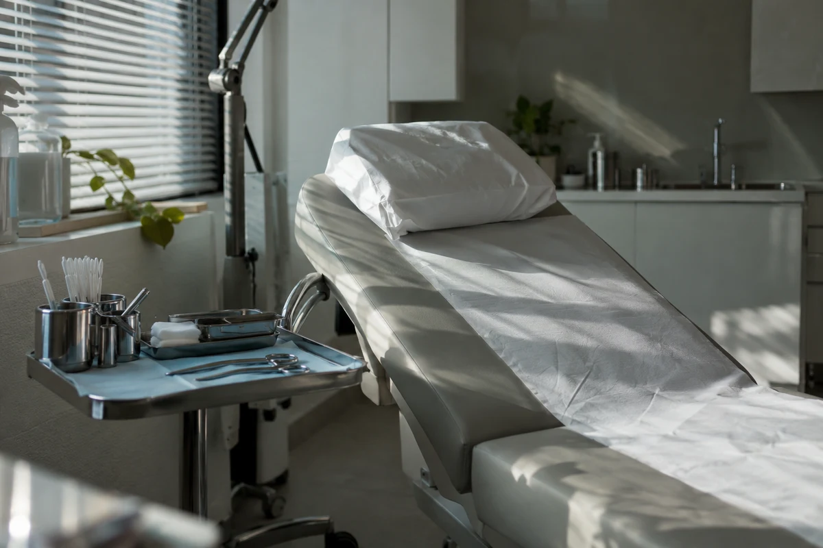An empty dental chair beside a softly lit window.